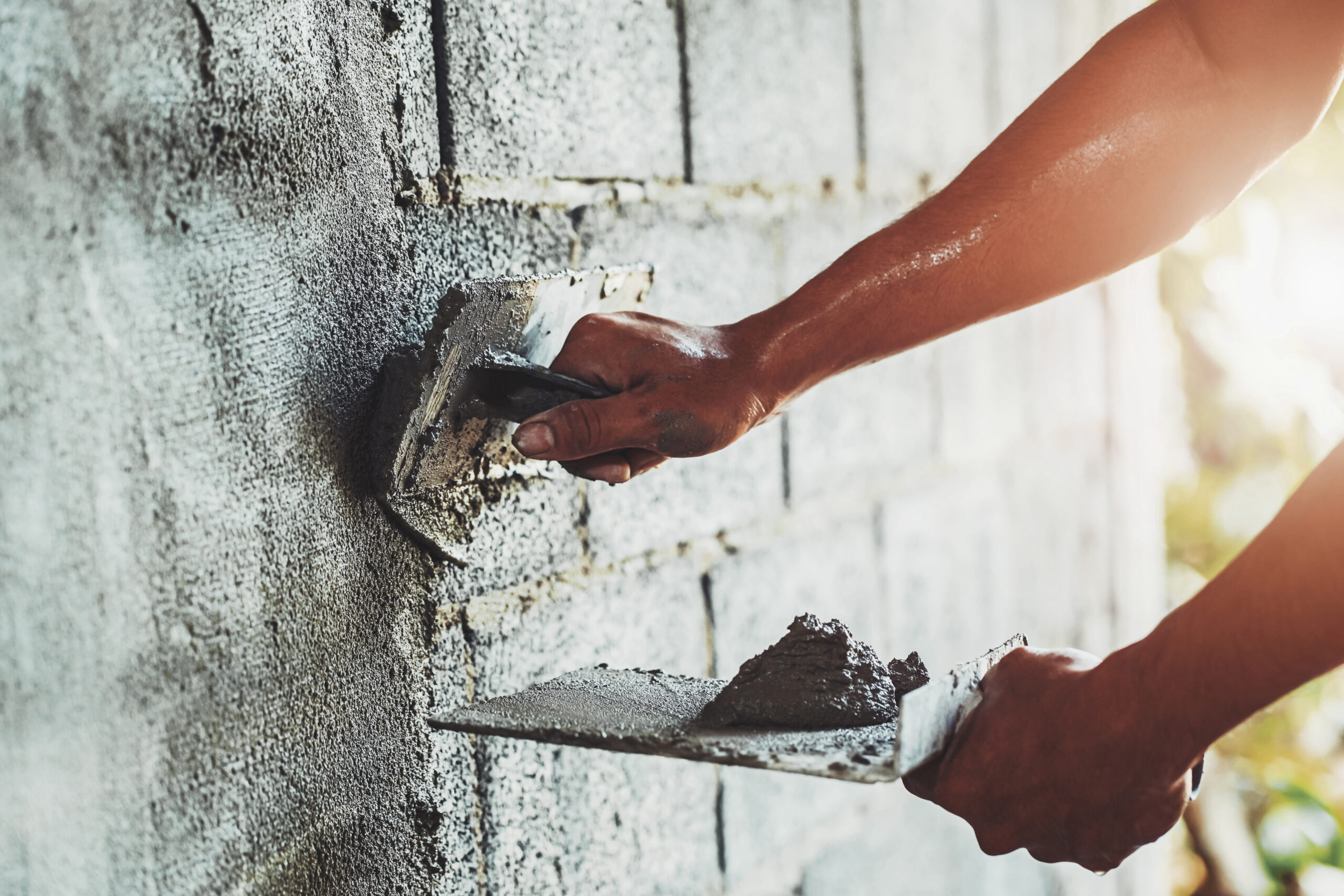 closeup hand of worker plastering cement at wall for building house