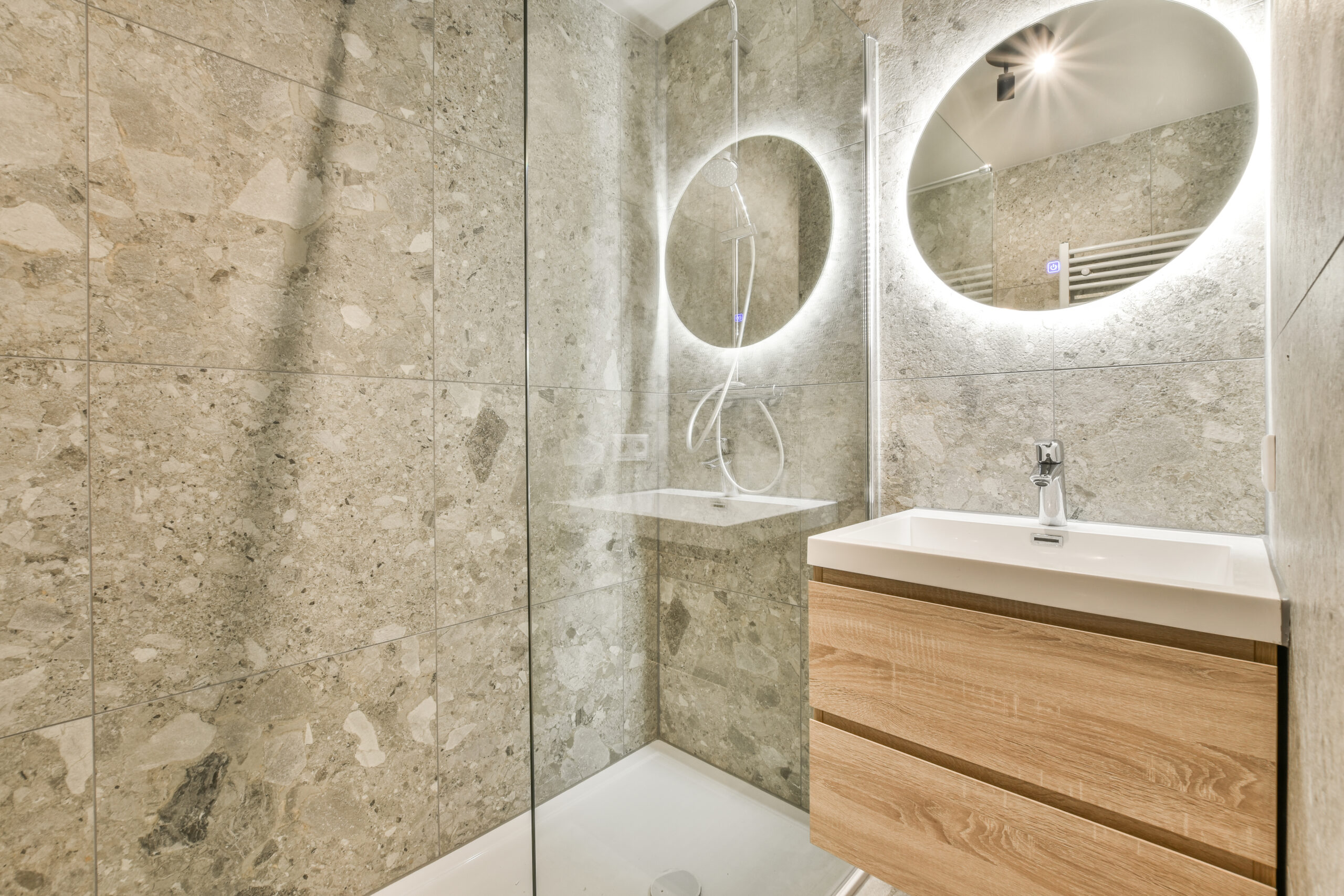 Modern black shower column in expensive open bathroom with gray tiled wall and window