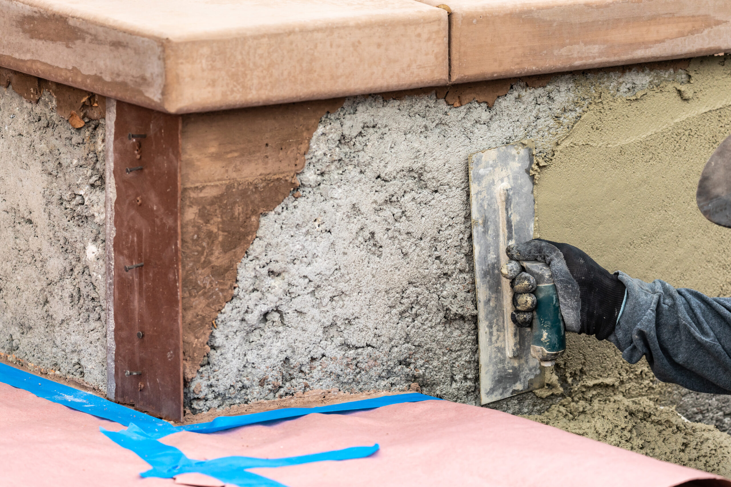 Tile Worker Applying Cement with Trowel at Pool Construction Site.